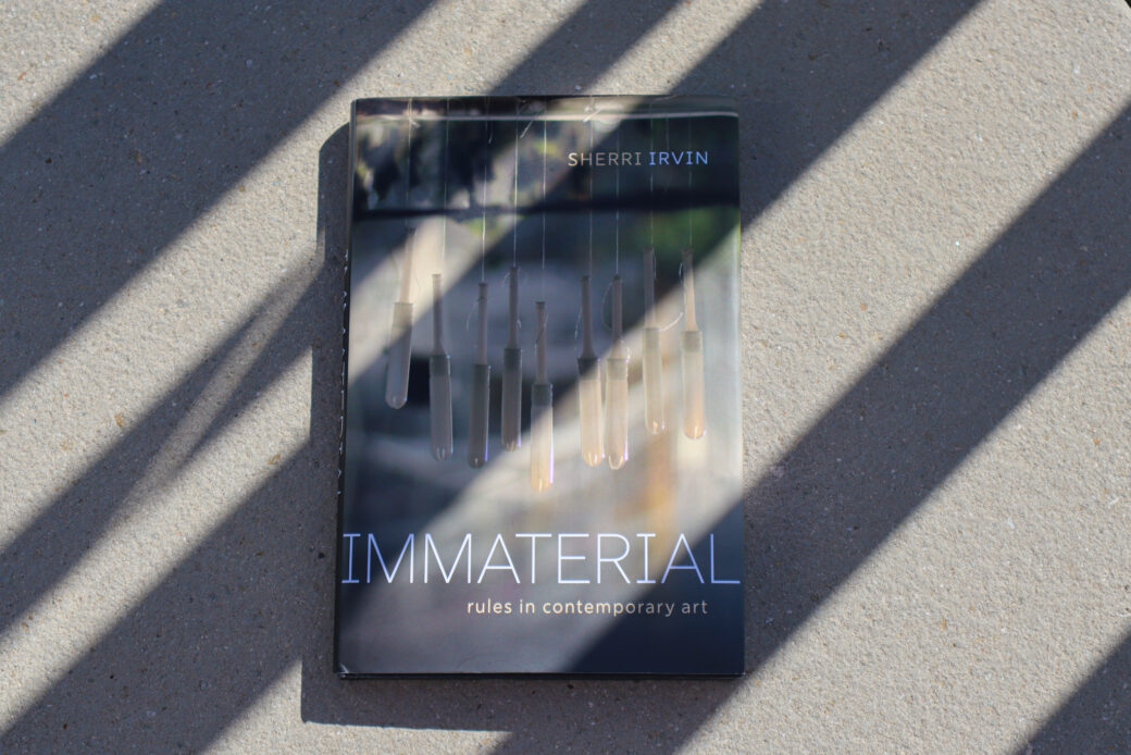 A book lays on a table with stripes of shadow and sunlight across it
