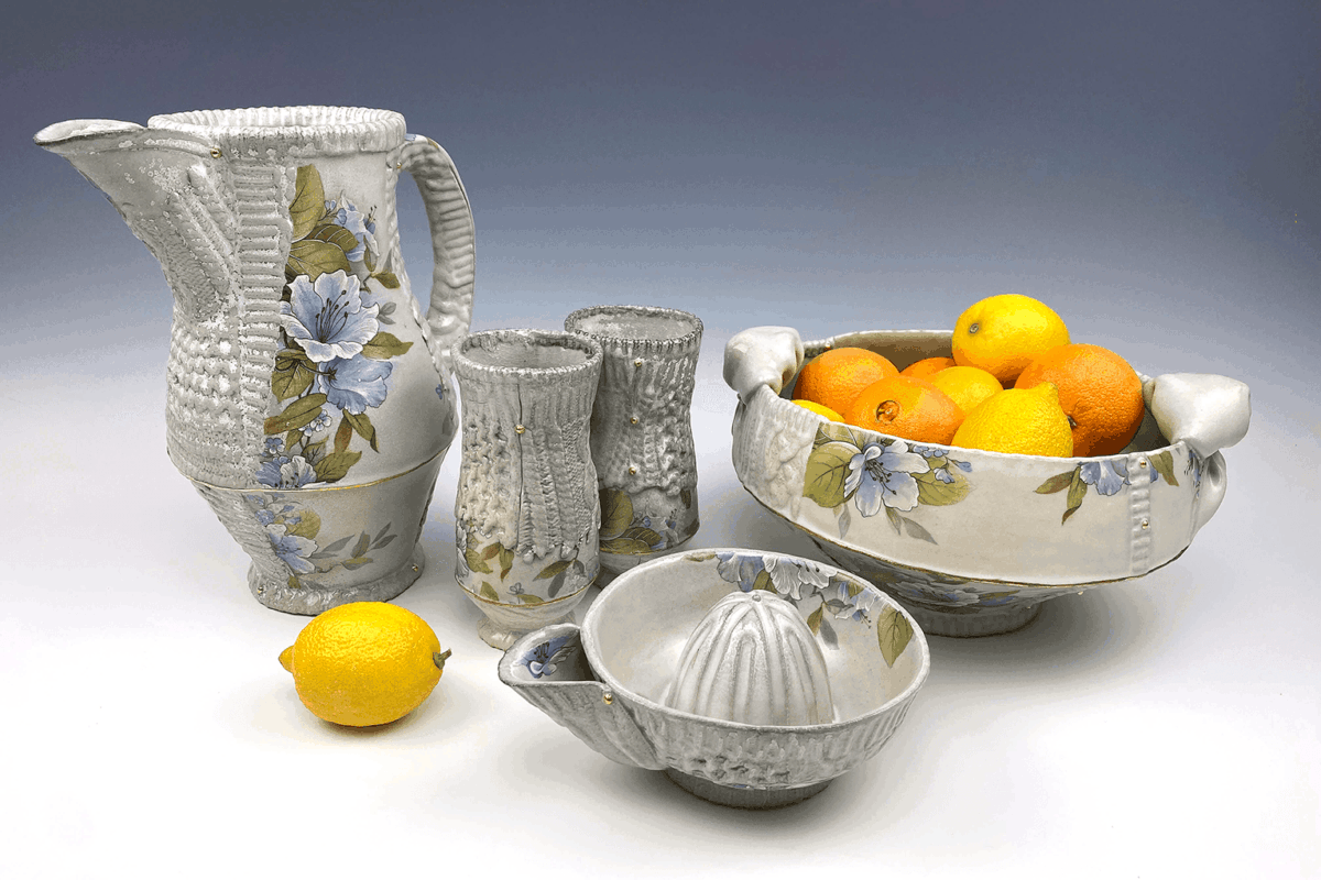 A ceramic pitcher, bowl and citrus juicer