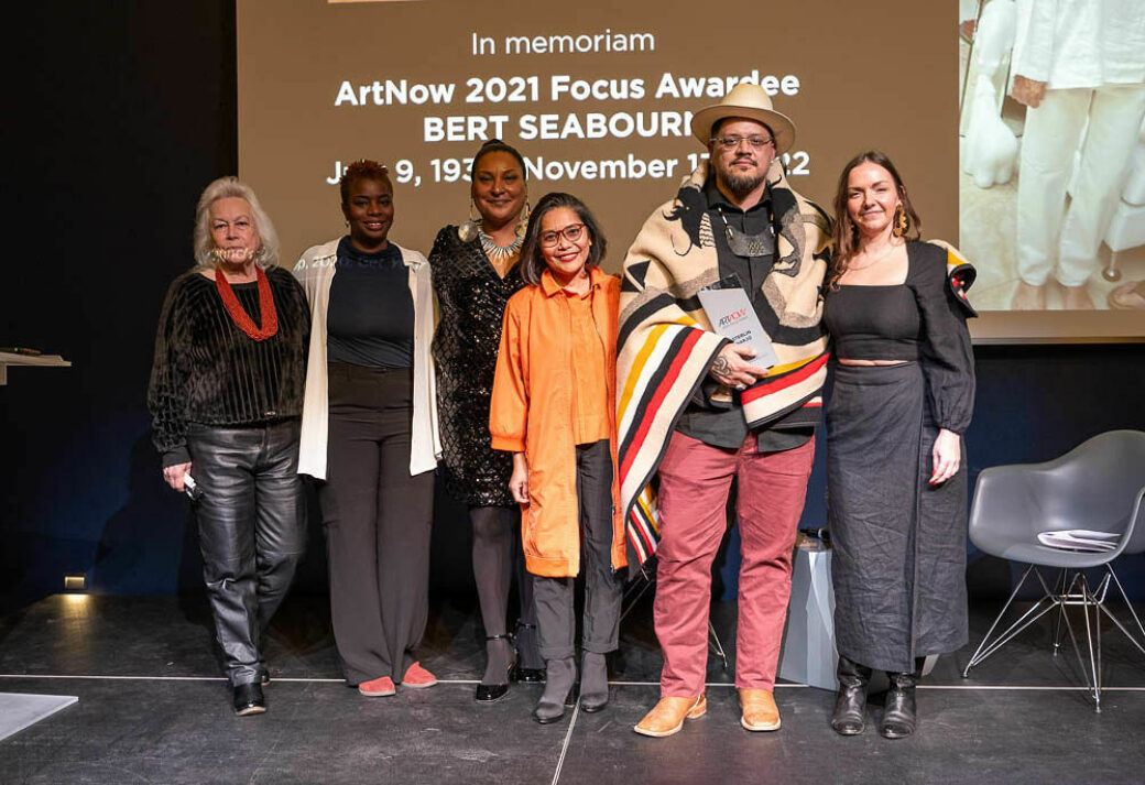 A group of people stand with Sterlin Harjo, who is holding the ArtNow 2023 Focus Award