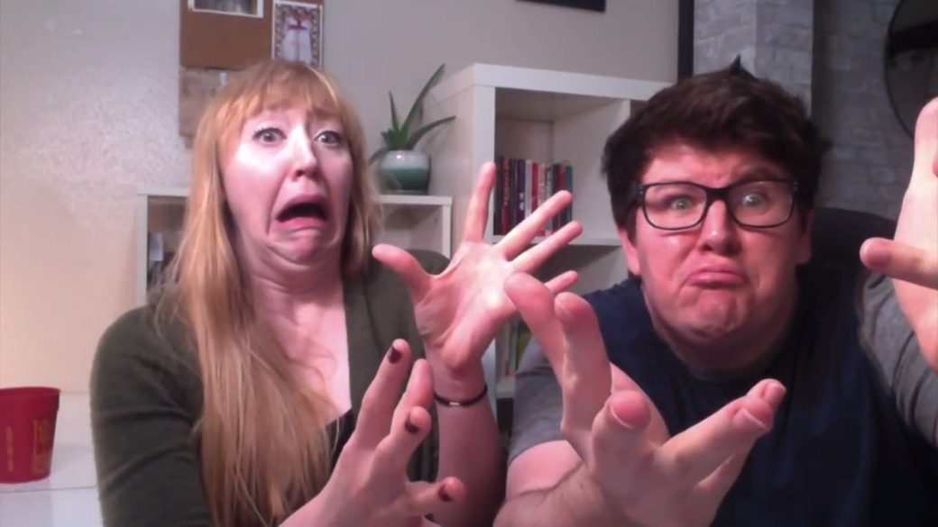Two people make silly faces at a webcam
