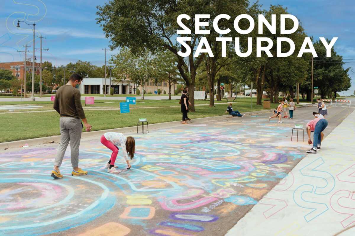 Children and adults create a colorful chalk mural on pavement