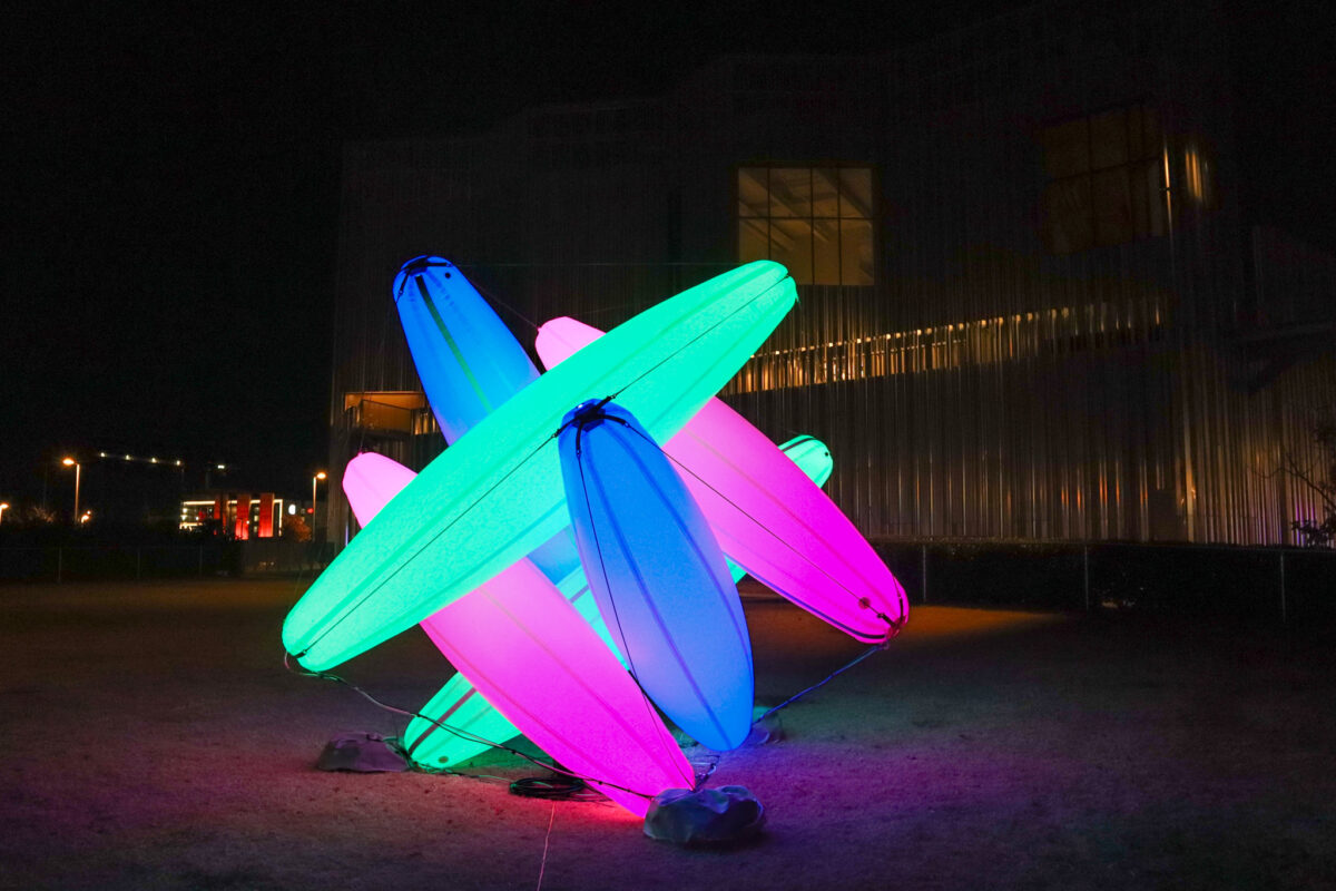 An inflatable form of interlocking green, blue and pink columns illuminated from within