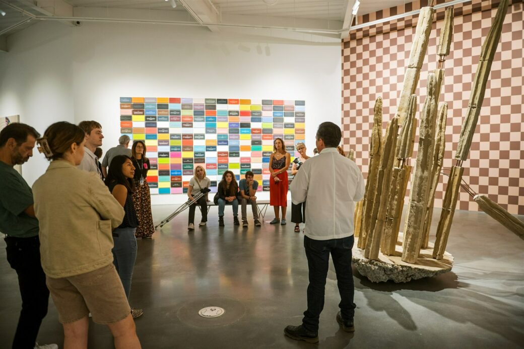 A person talks to a group in an art gallery