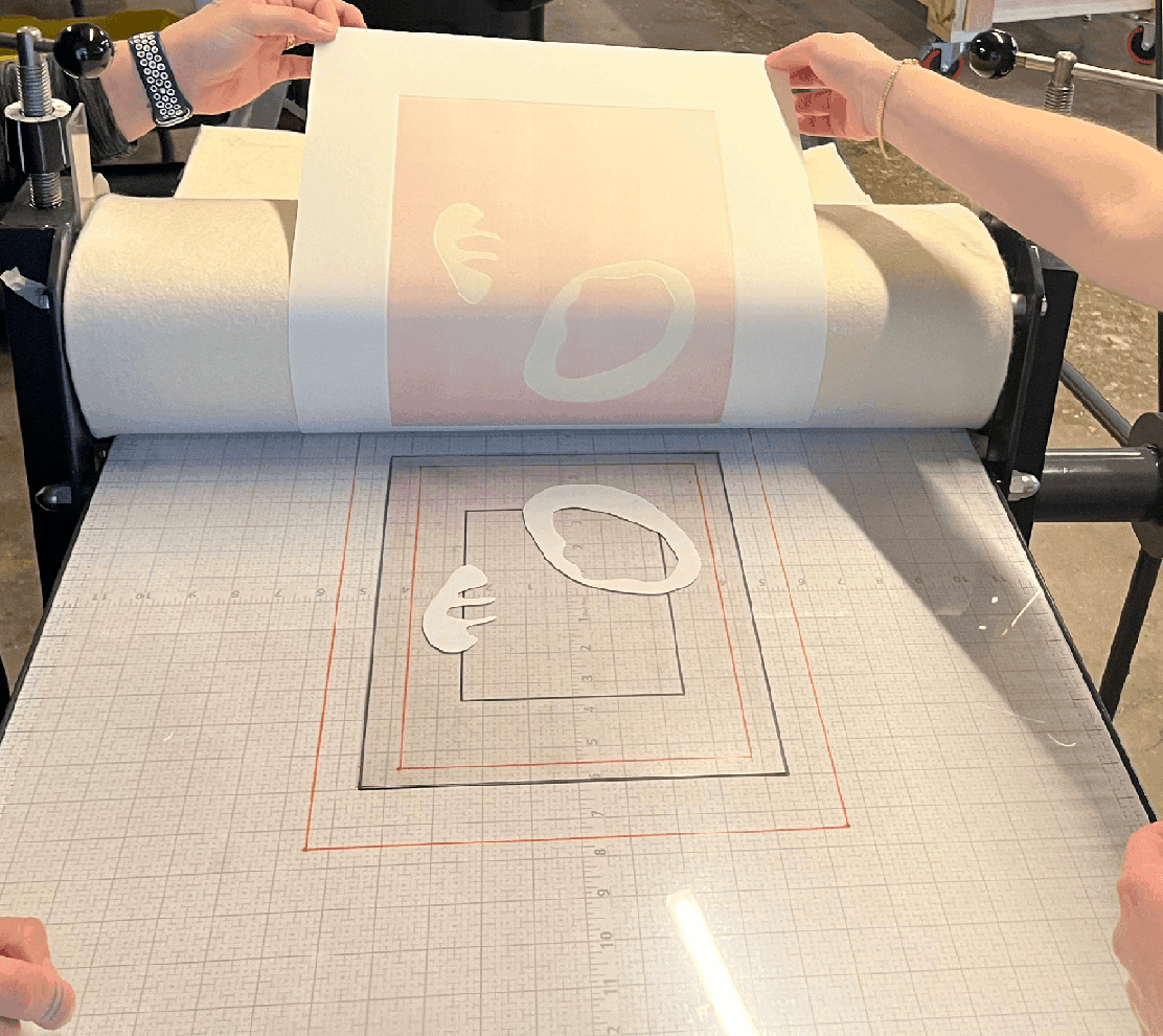Hands peel a printed paper from a template
