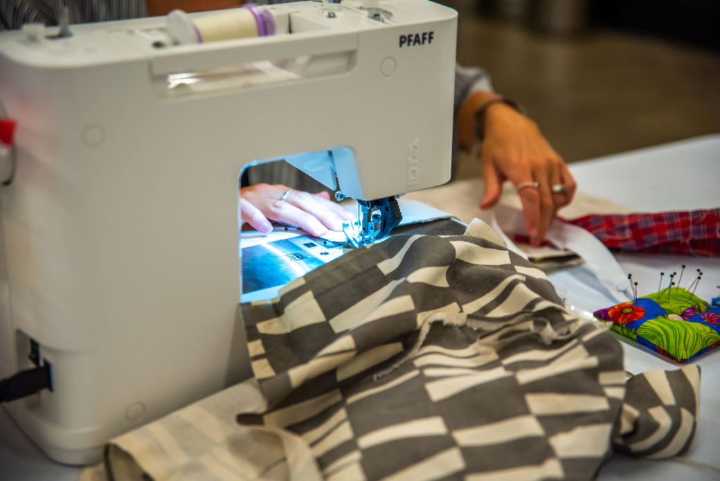 image of black and white fabric being passed through a sewing machine