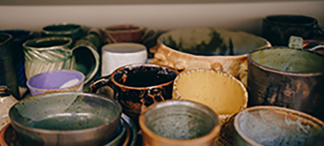 Image of several ceramic mugs of various colors like grey, yellow, green, and brown.