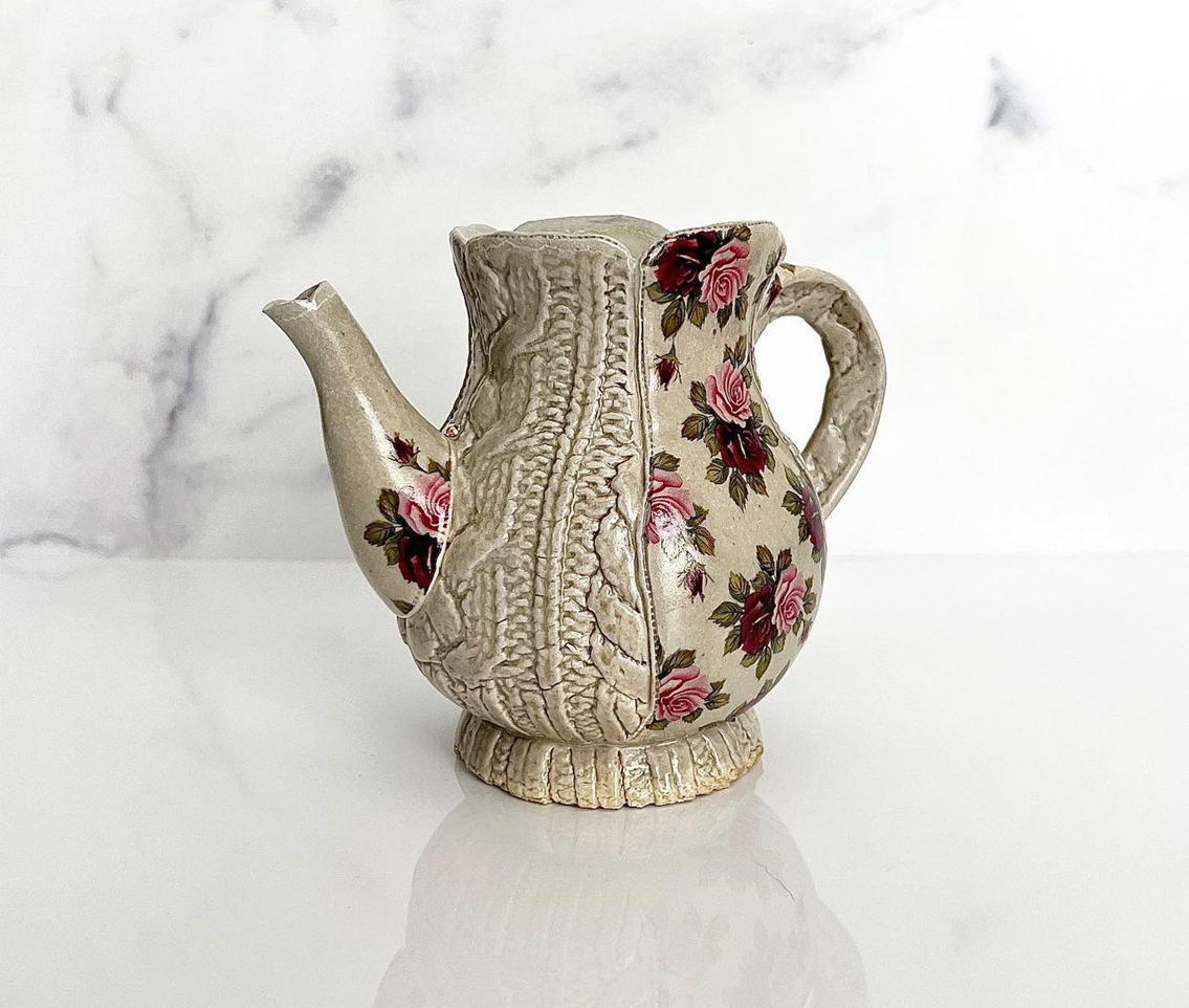 A ceramic pitcher covered in floral designs and cable-knit textures