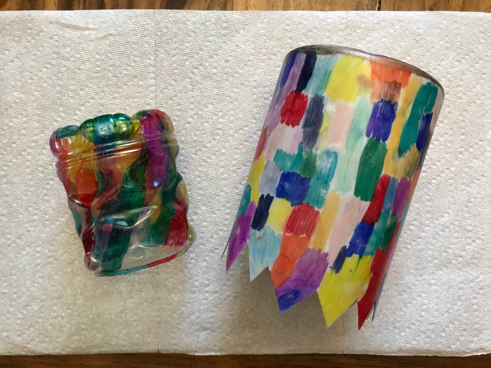 Two modified plastic containers hand painted in multiple colors