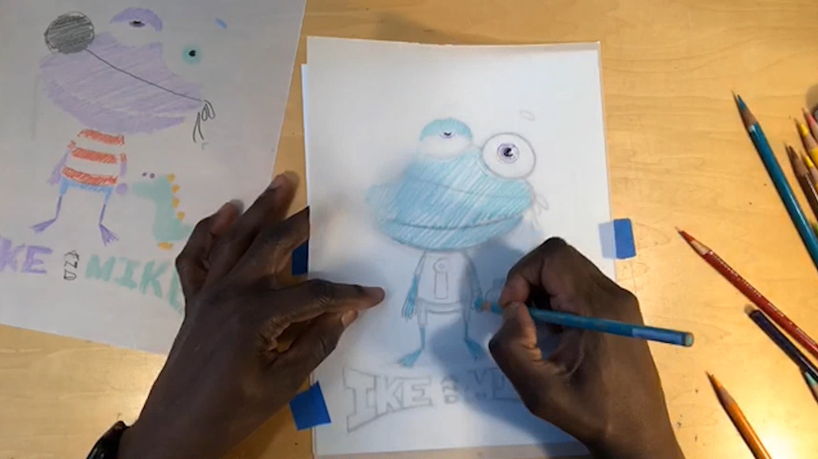 Two hands coloring a drawing of a cartoon character with a blue colored pencil