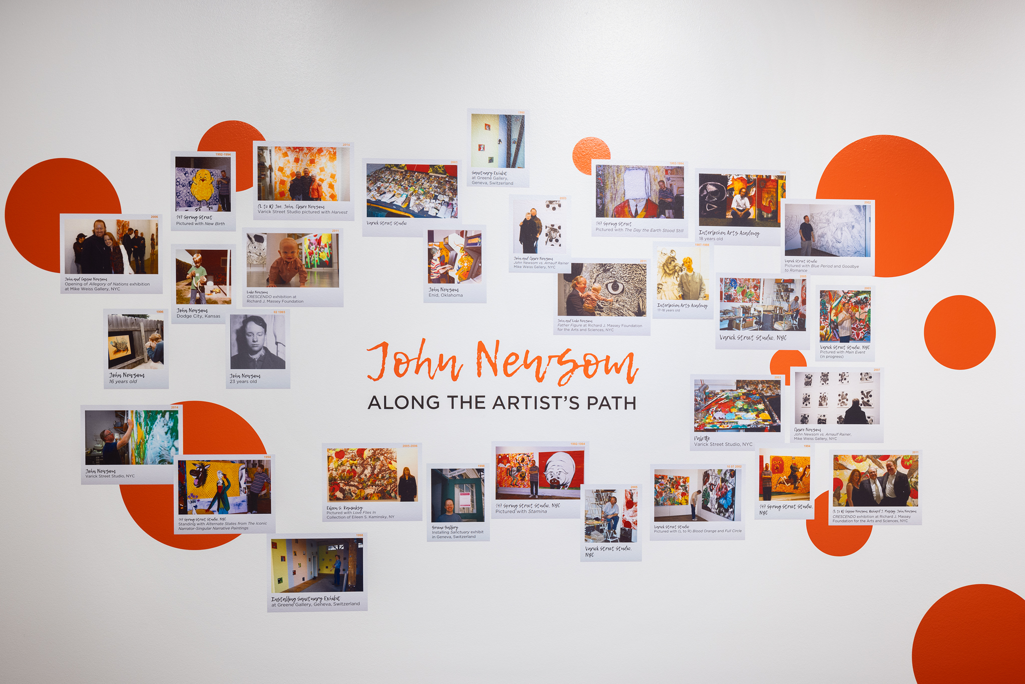 A collage wall of vinyl-printed images is in frame, bright red circles floating behind. The text in the middle says John Newsom in bright red. Below it reads Along the Artist's Path in black.