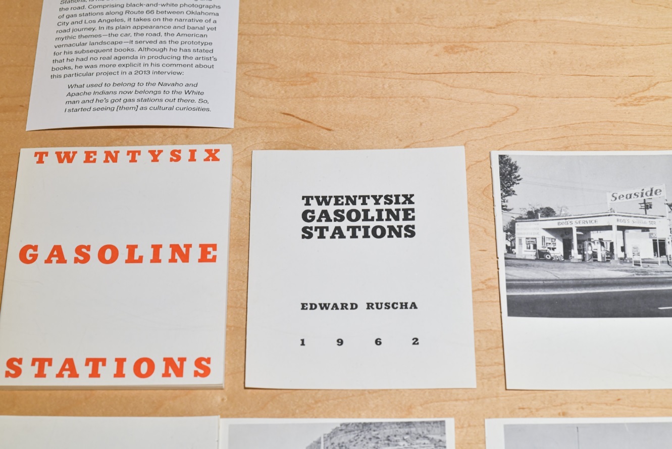 Individual pieces of paper printed with text and images of gas stations along with the text TWENTYSIX GASOLINE STATIONS displayed together
