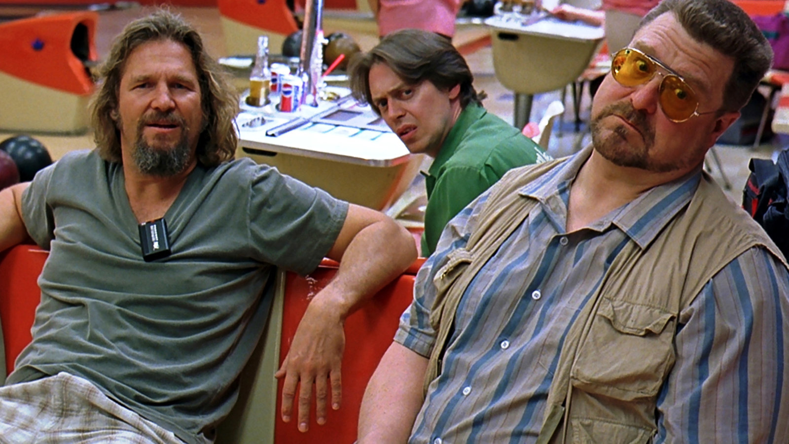 A scene from The Big Lebowski depicts three of its main characters sitting in a bowling alley