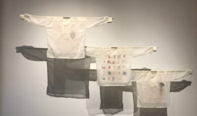 Three white shirts with faint designs suspended in mid-air
