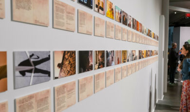 A woman looks at rows of postcard-sized photographs and text