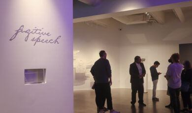 A wall to the left reads "Fugitive Speech." A group of people stand in a gallery to the right.