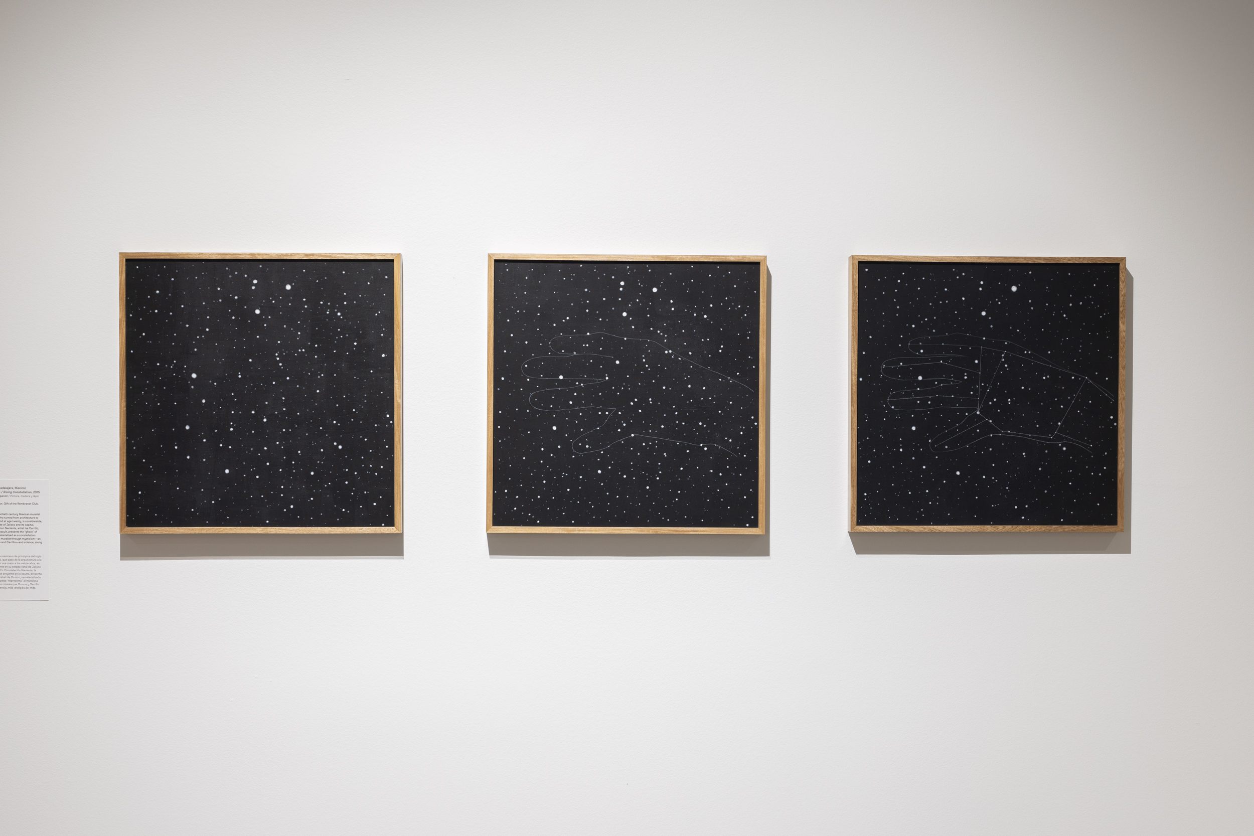 A triptych of black canvases with stars. The first has a constellation of a hand and the hand fades out of the following canvases.