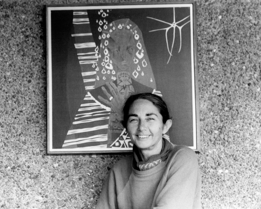 Black and white image of a woman standing next to an abstract artwork