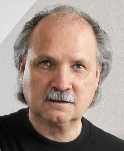 Close up of a man with gray hair and a mustache