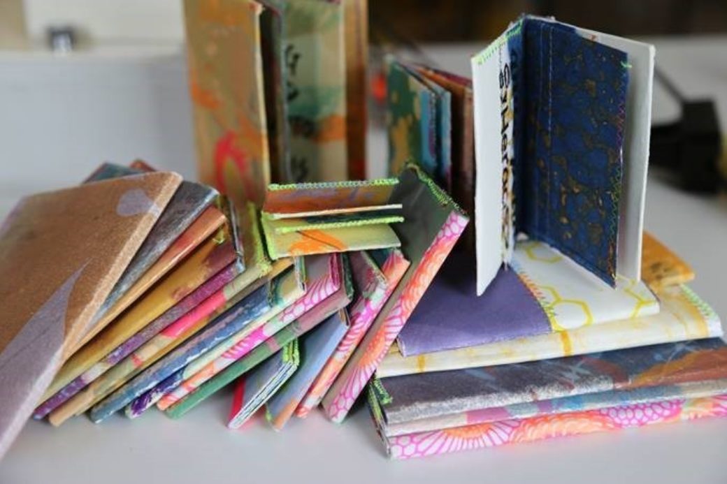 A collection of multicolored, hand-bound books