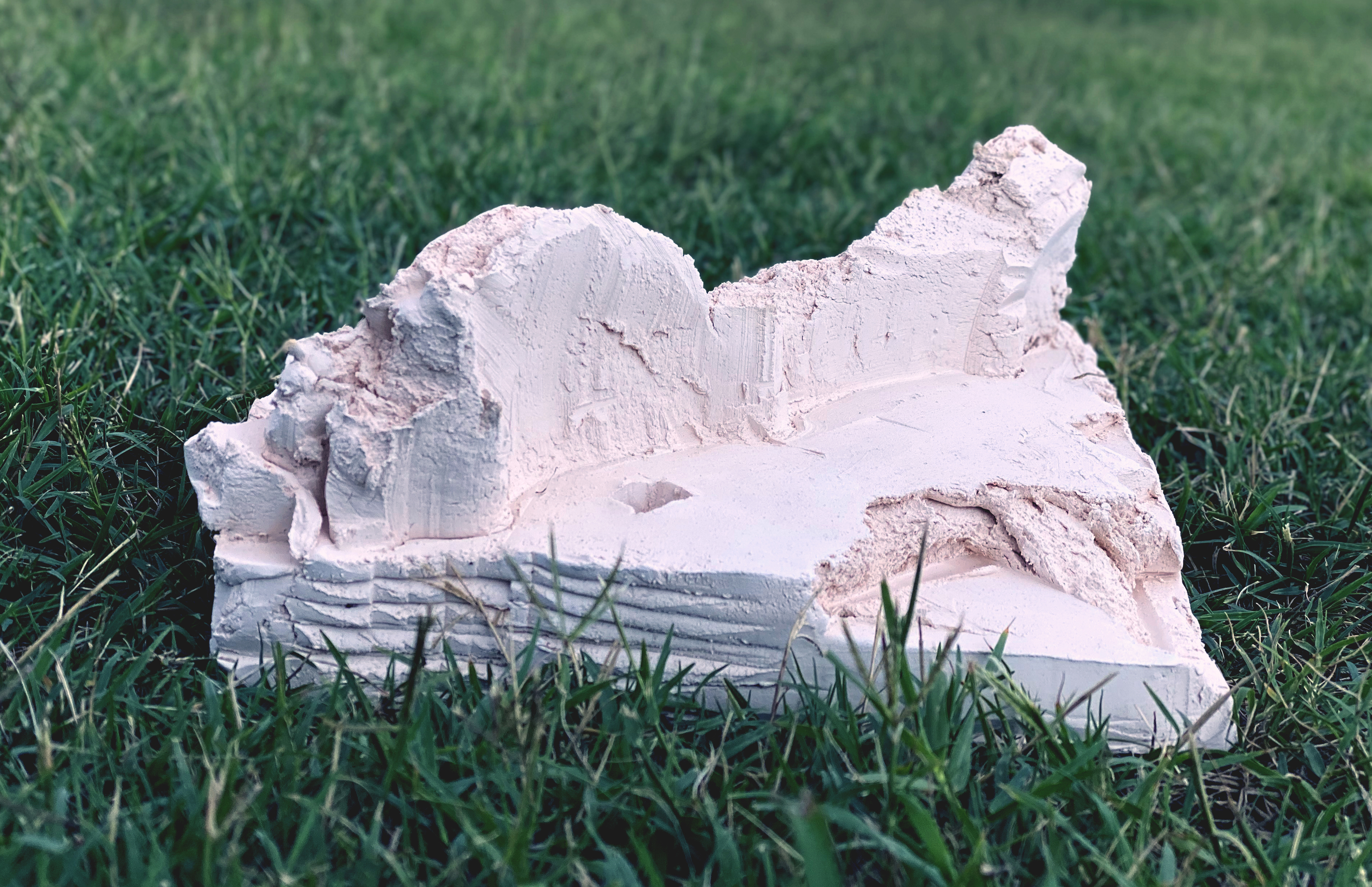 An abstract ceramic chunk, pictured sitting atop green grass in a tightly cropped photo