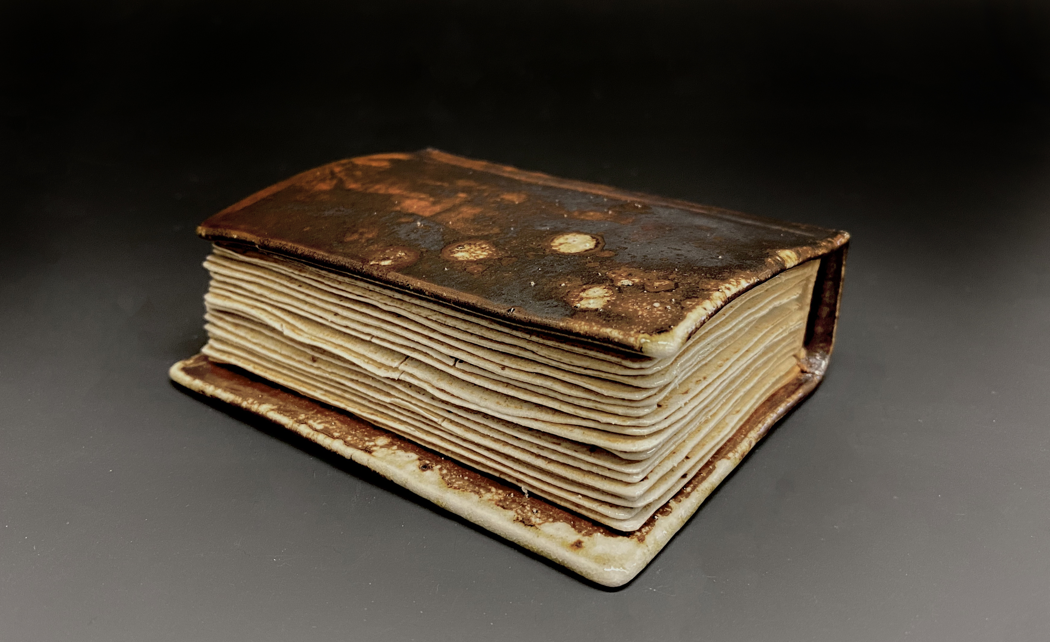 A ceramic sculpture depicts what appears to be an ancient book