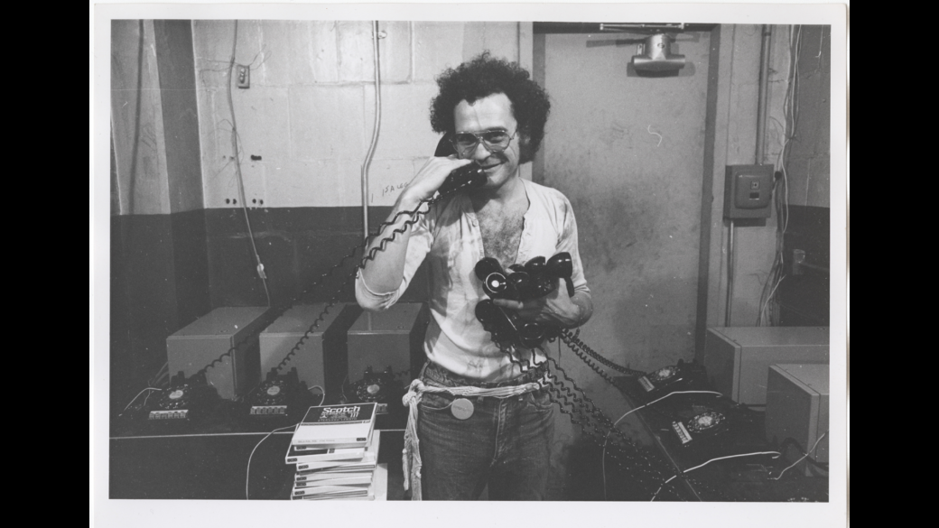John Giorno holds a bunch of telephone handsets