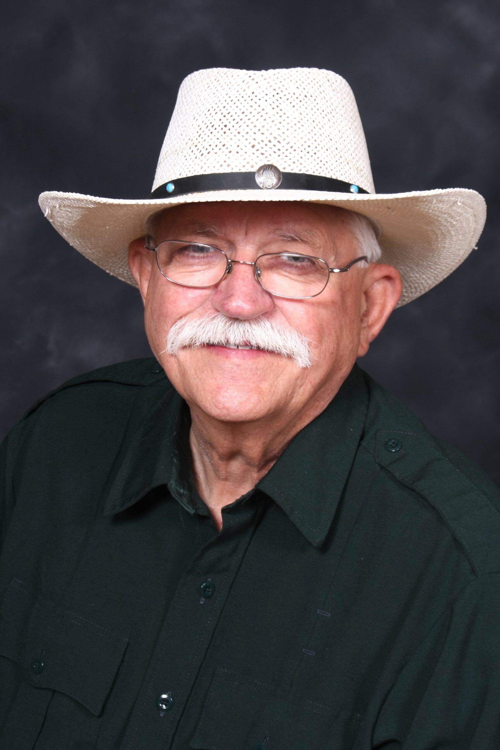 Photo of Patrick Riley, a man in a light-colored cowboy hat and black shirt