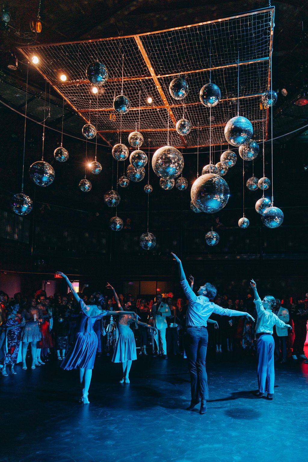 Dancers perform under disco balls