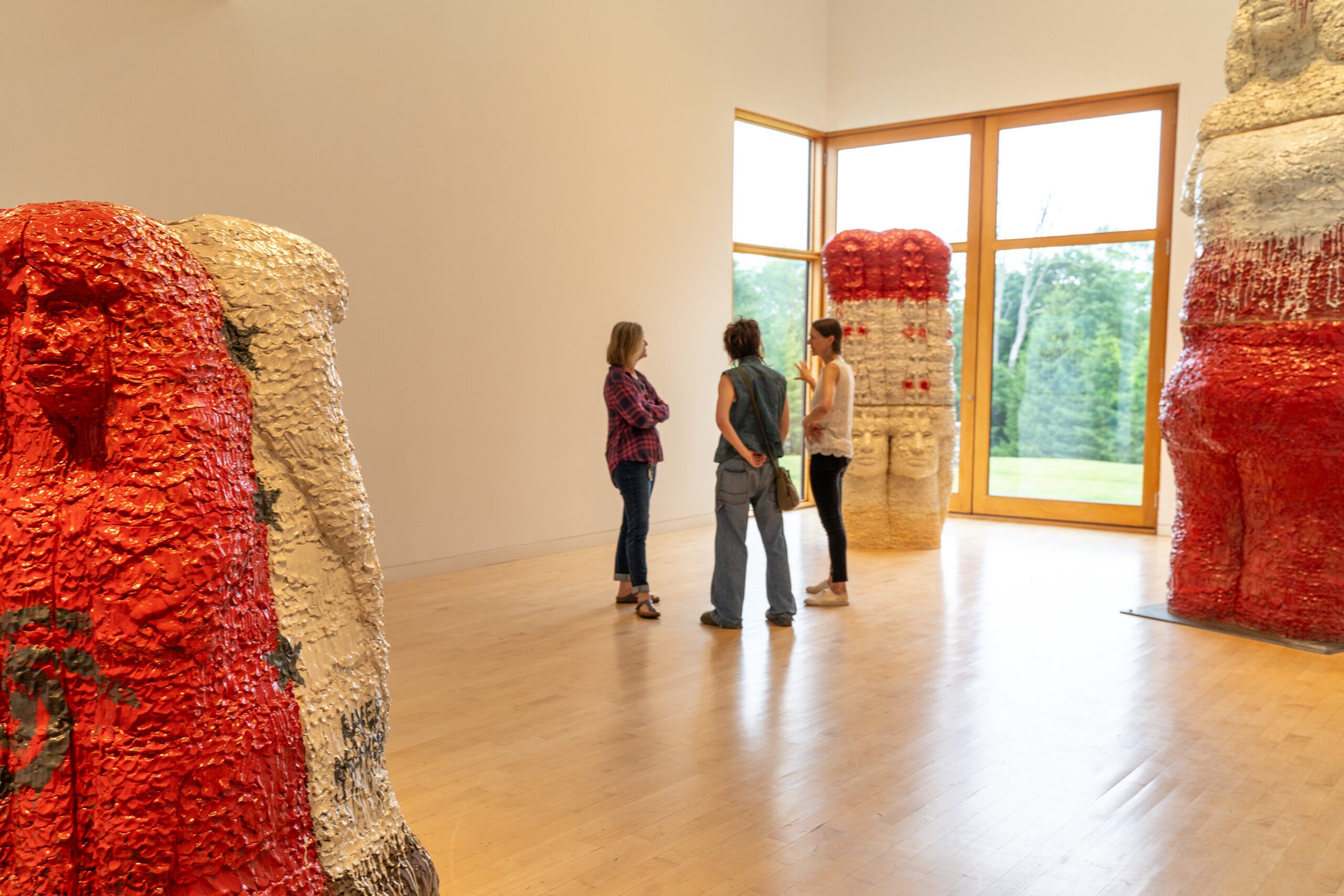 Three people in a gallery full of large-scale sculptures