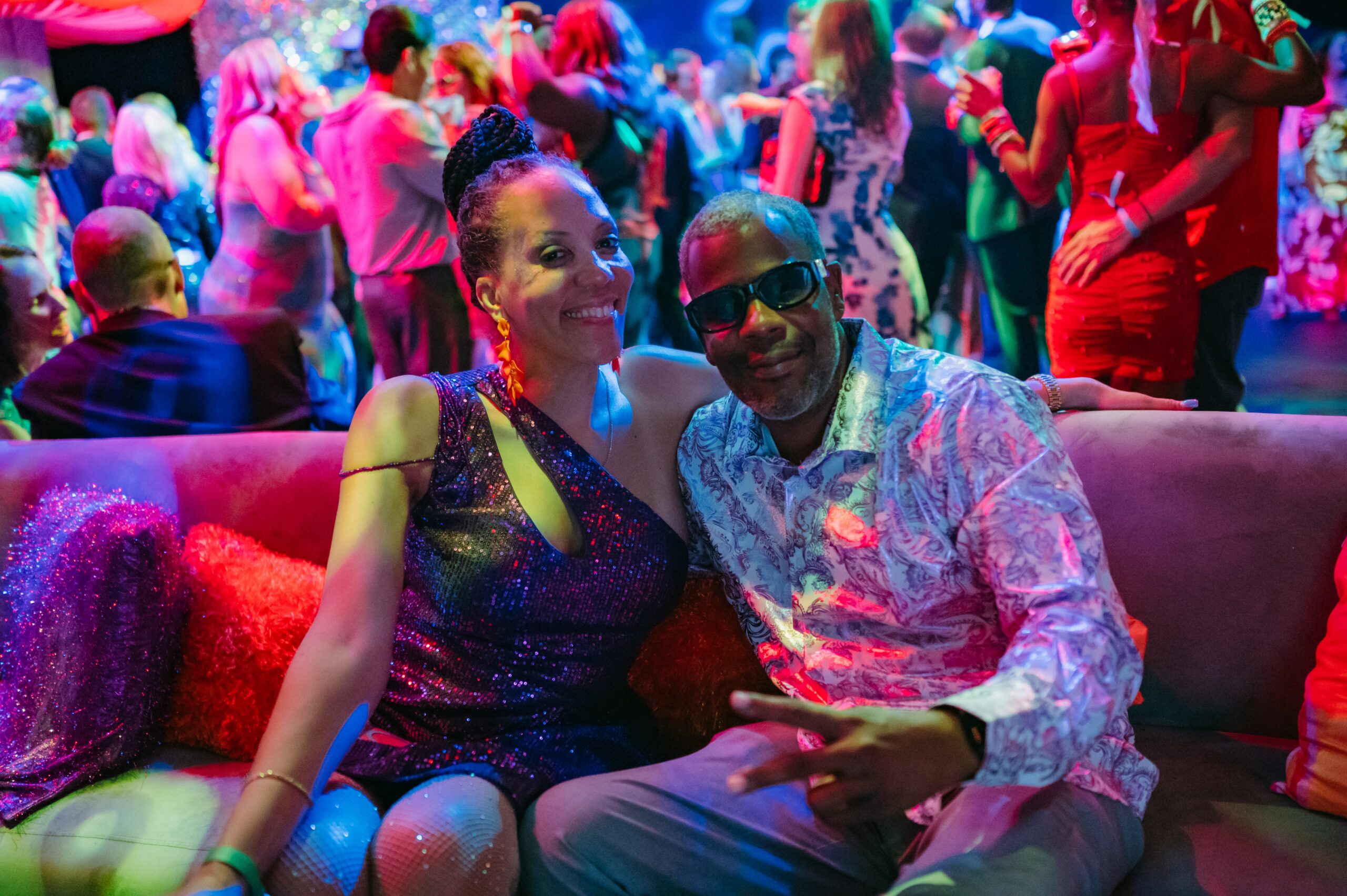 People smiling at a party with colorful lights