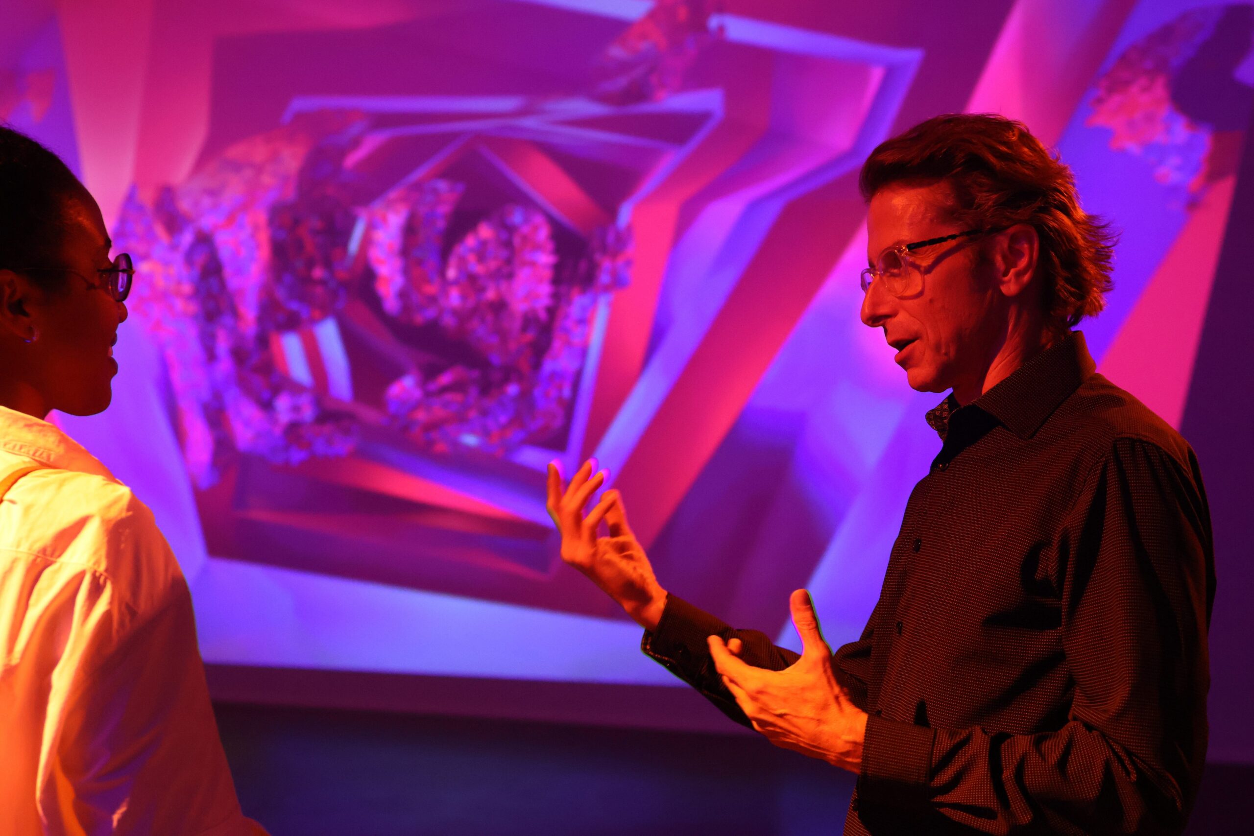 Artist Chad Mount stands in front of one of his light projections