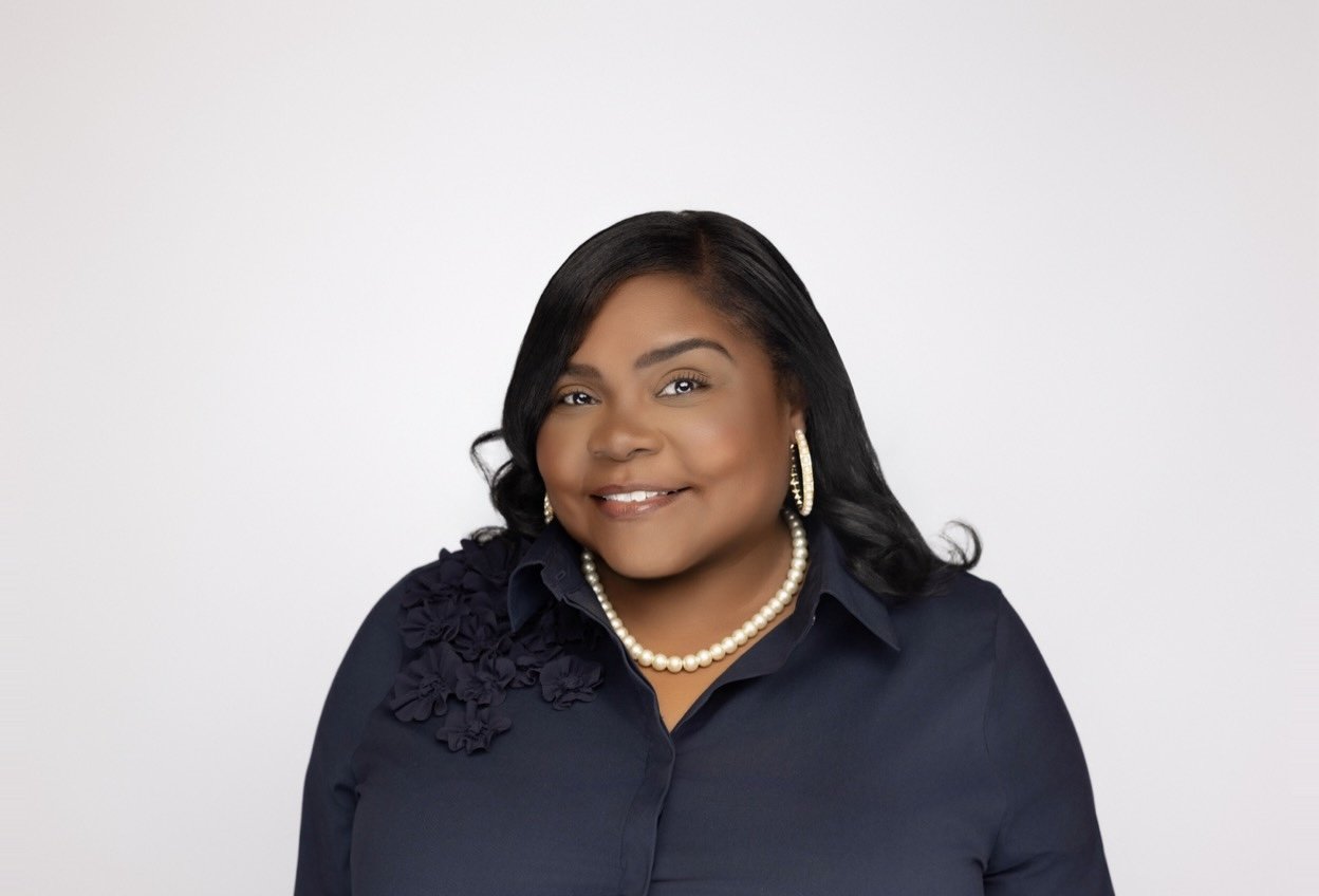Photo of Kristi Williams, a Black woman wearing pearl jewelry and a navy blouse