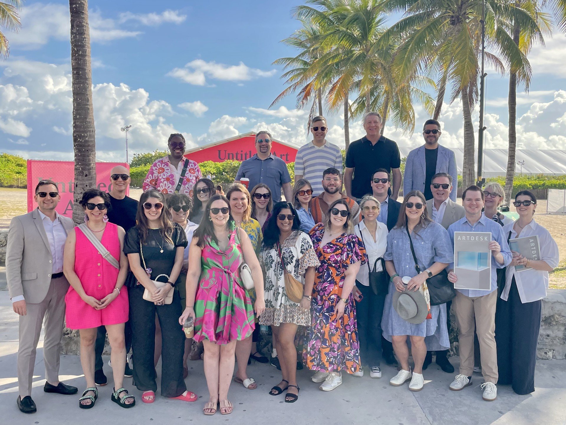 A group of people pose in a tropical setting